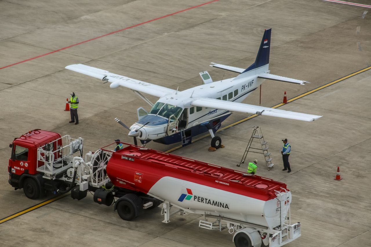 about-01 A small aircraft being refueled on an airport tarmac with workers present.