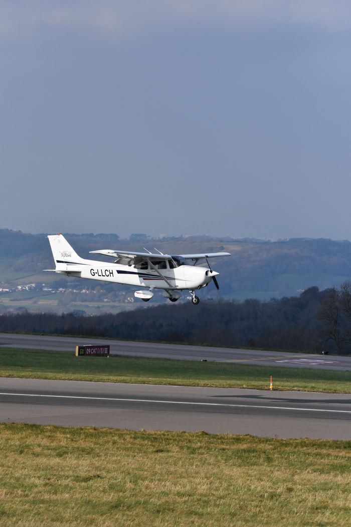 services-01 A small aircraft lifts off the runway, soaring over scenic landscape on a clear day.